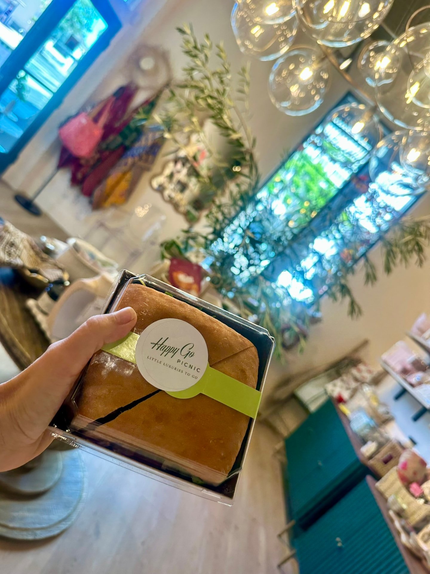 A boxed Happy Go Picnic sandwich held up in the shop
