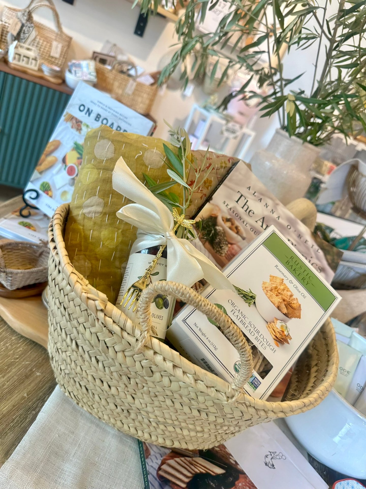 A small woven basket of pantry gifts and a picnic book in the shop